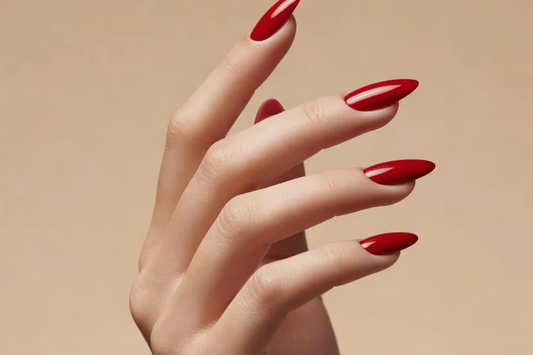 A hand with glossy red almond nails